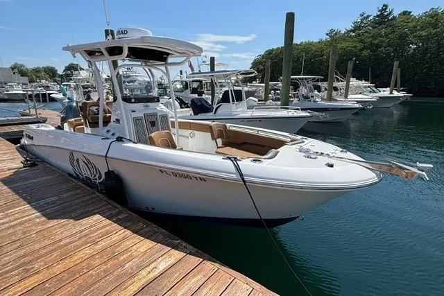 Slide: The Image of 2021 Wellcraft 242 Fisherman boat docked at marina, featuring sleek design and spacious deck. - 1