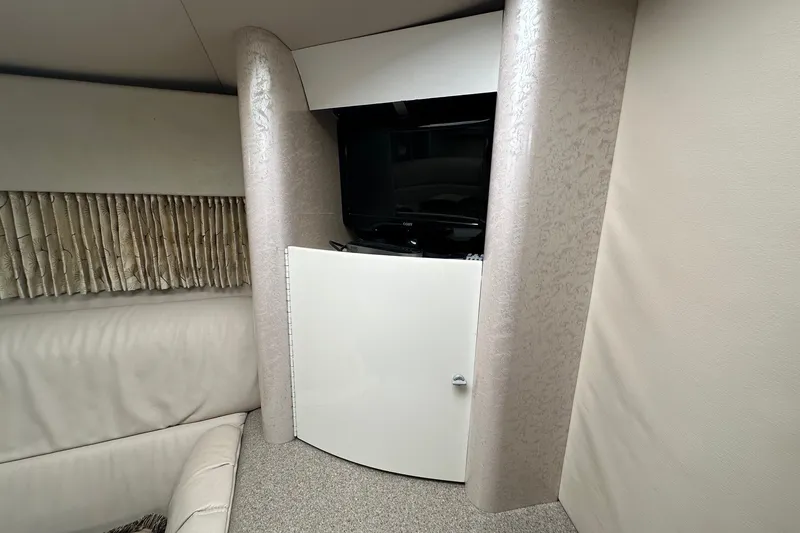 Slide: The Image of Interior of a 1999 Formula 400 Super Sport boat with TV and seating area. - 16