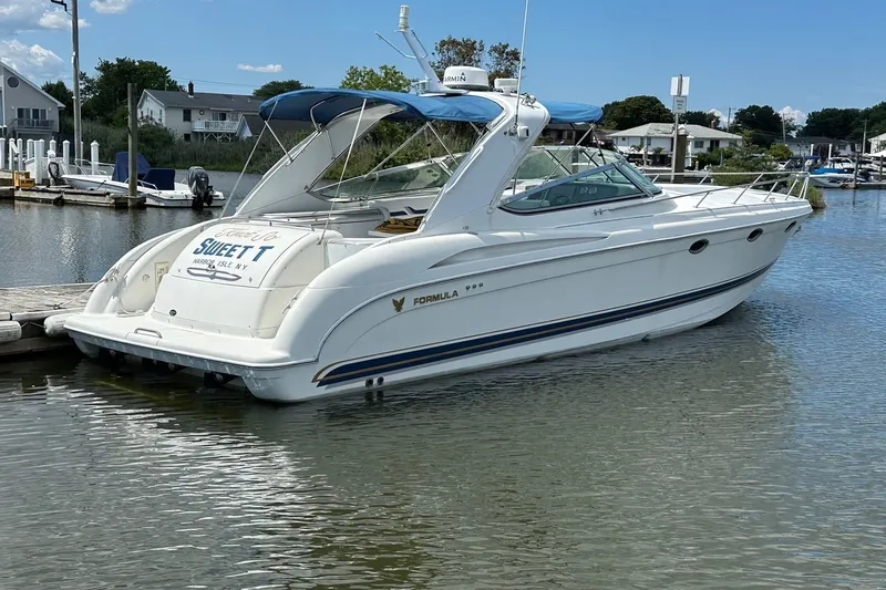 The Image of 1999 Formula 400 Super Sport boat docked in a marina, featuring sleek white design. - 0
