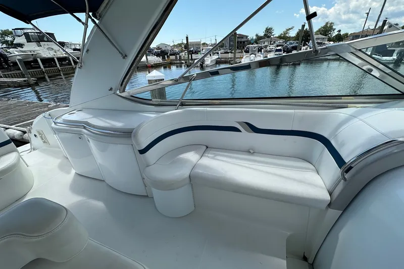 Slide: The Image of 1999 Formula 400 Super Sport boat interior with white seating and marina view. - 6