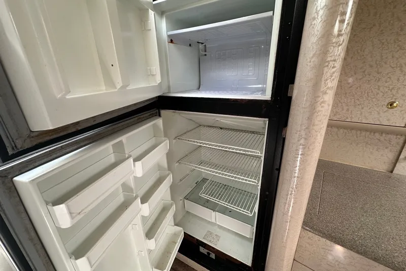 Slide: The Image of Empty refrigerator inside a 1999 Formula 400 Super Sport boat cabin. - 14