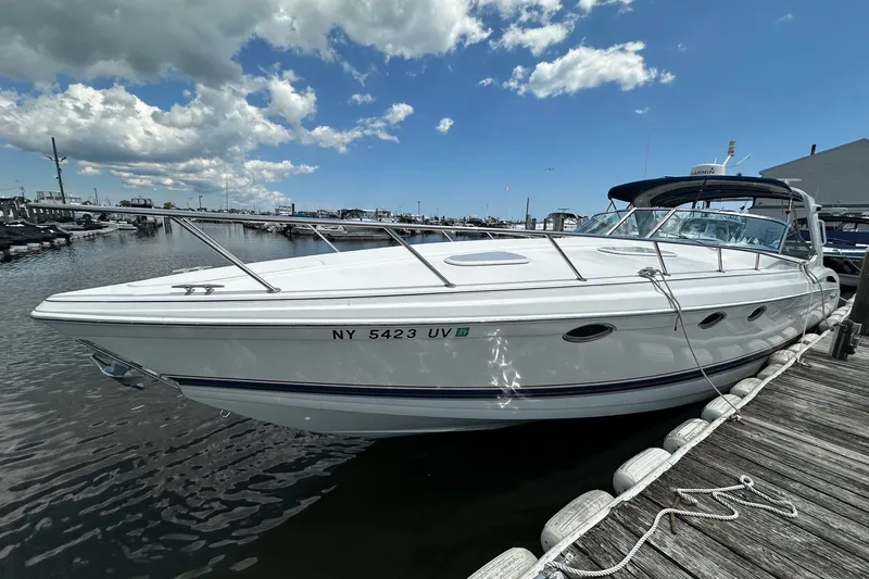 Slide: The Image of 1999 Formula 400 Super Sport boat docked at marina under blue sky. - 1