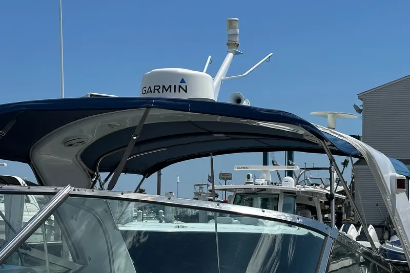 Slide: The Image of 1999 Formula 400 Super Sport boat with Garmin radar, docked under clear blue sky. - 4