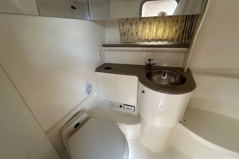 Slide: The Image of 1999 Formula 400 Super Sport boat bathroom with sink, toilet, and mirror. - 17