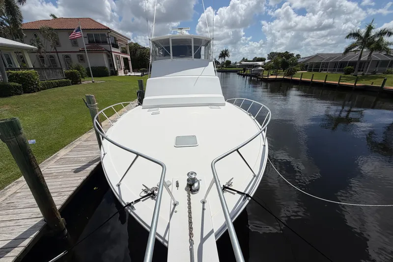 Slide: The Image of 2007 Post 50 Convertible yacht docked by waterfront homes under a partly cloudy sky. - 3
