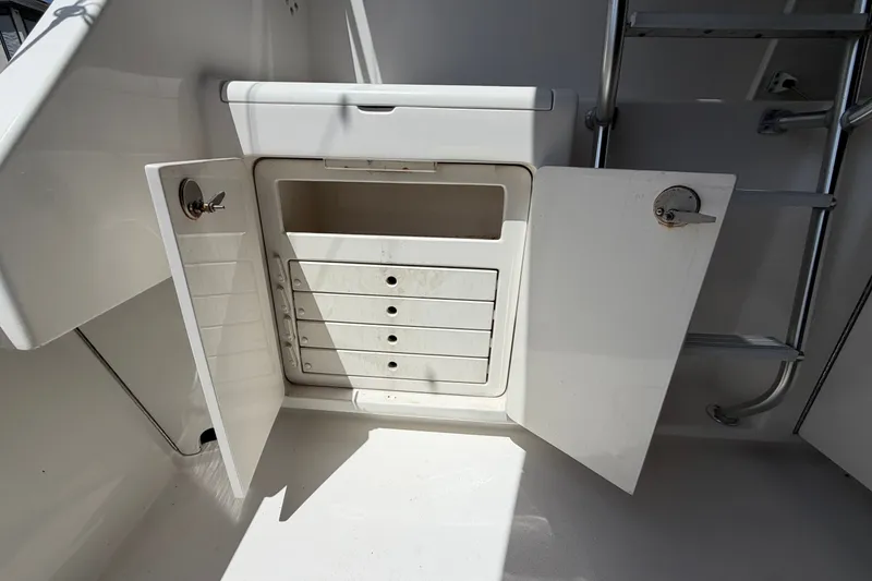 Slide: The Image of Open storage compartment on 2007 Post 50 Convertible boat with ladder nearby. - 16