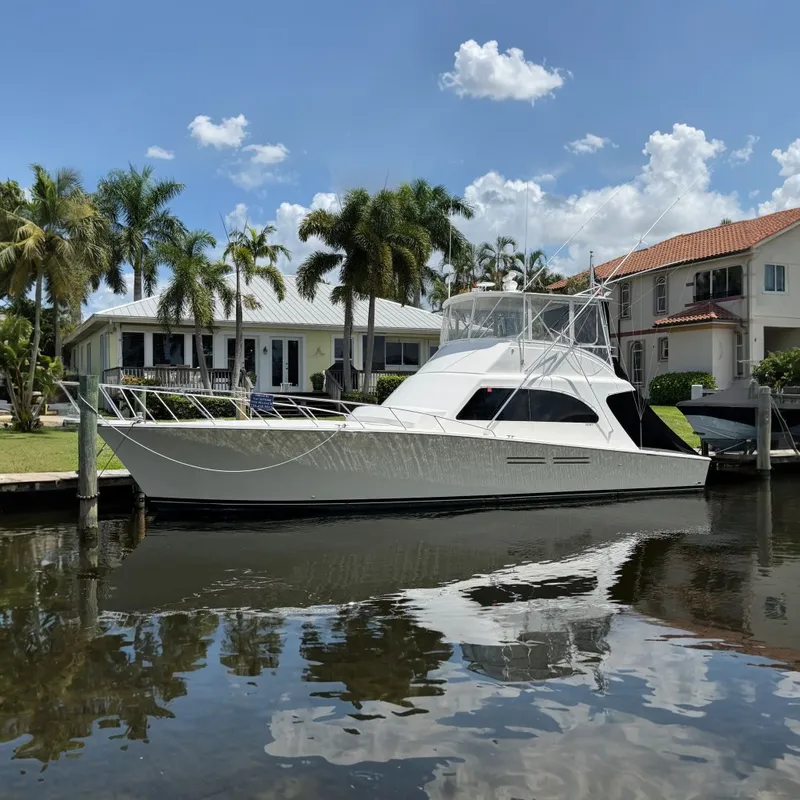 The Image of 2007 Post 50 Convertible yacht docked by waterfront homes with palm trees. - 0