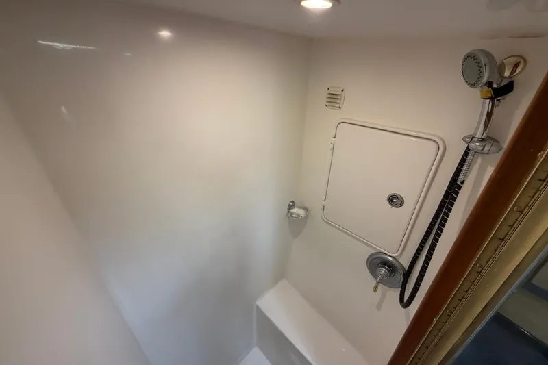 Slide: The Image of Shower area in 2007 Post 50 Convertible yacht, featuring a handheld showerhead and storage compartment. - 86