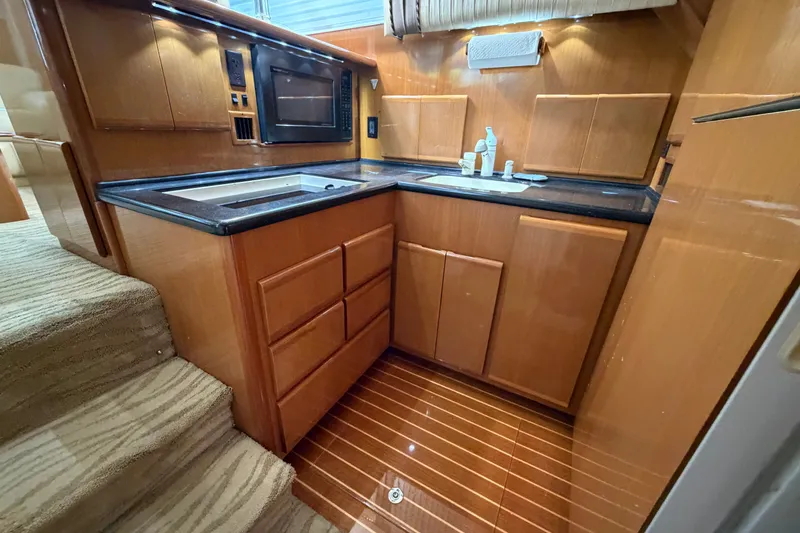Slide: The Image of Luxurious 2007 Post 50 Convertible yacht kitchen with wood cabinetry and modern appliances. - 61