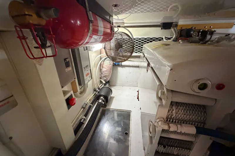 Slide: The Image of Engine room of a 2007 Post 50 Convertible yacht, featuring fire extinguisher and electrical components. - 112