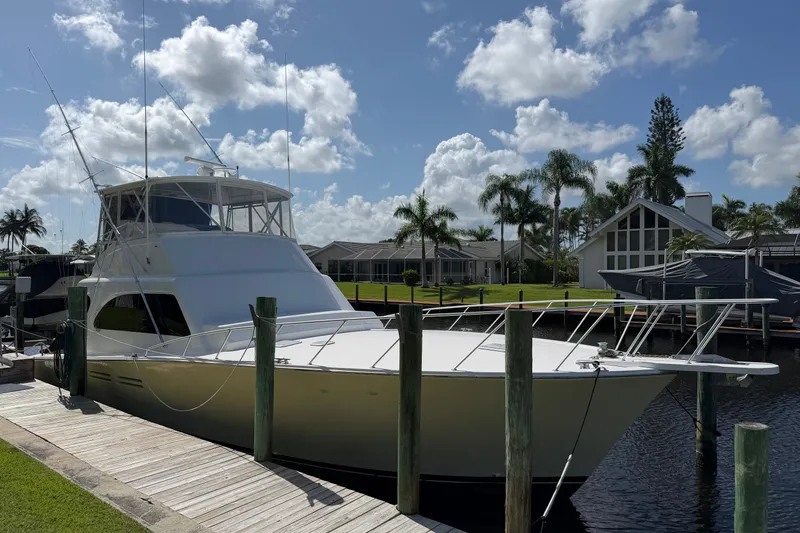 Slide: The Image of 2007 Post 50 Convertible yacht docked by waterfront homes under a partly cloudy sky. - 2