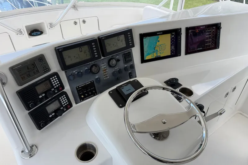 Slide: The Image of Control panel of a 2007 Post 50 Convertible yacht with navigation screens and steering wheel. - 24