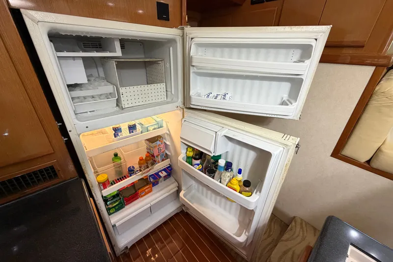Slide: The Image of Open refrigerator in a 2007 Post 50 Convertible yacht, stocked with various food items and beverages. - 62