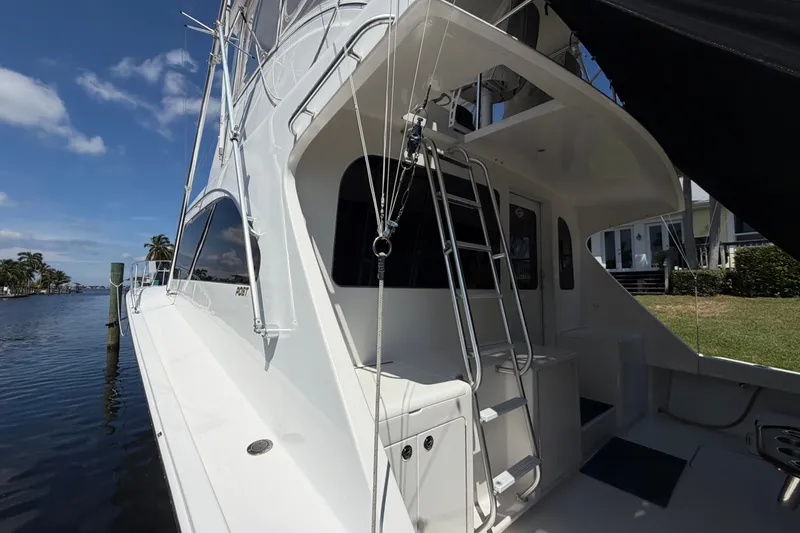 Slide: The Image of 2007 Post 50 Convertible yacht docked by a waterfront property under a clear blue sky. - 12