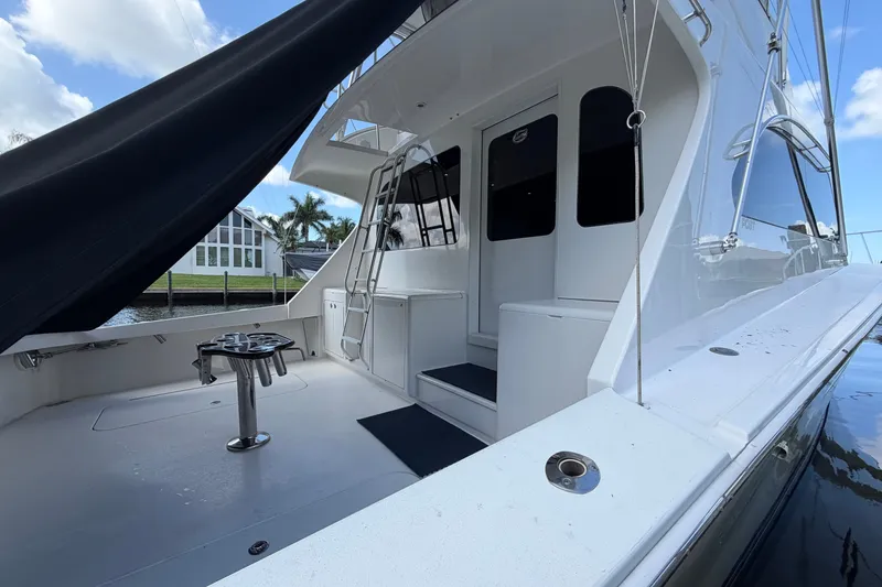 Slide: The Image of 2007 Post 50 Convertible yacht deck with seating and ladder, docked by waterfront homes. - 11