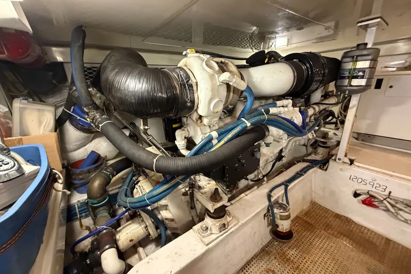 Slide: The Image of Engine room of a 2007 Post 50 Convertible yacht, showcasing complex machinery and hoses. - 99