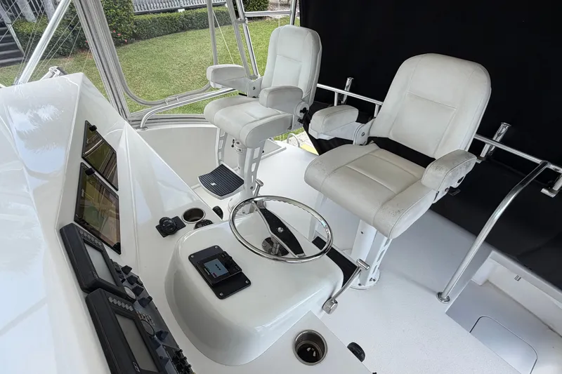 Slide: The Image of Luxurious 2007 Post 50 Convertible yacht cockpit with dual white captain chairs and advanced navigation controls. - 23