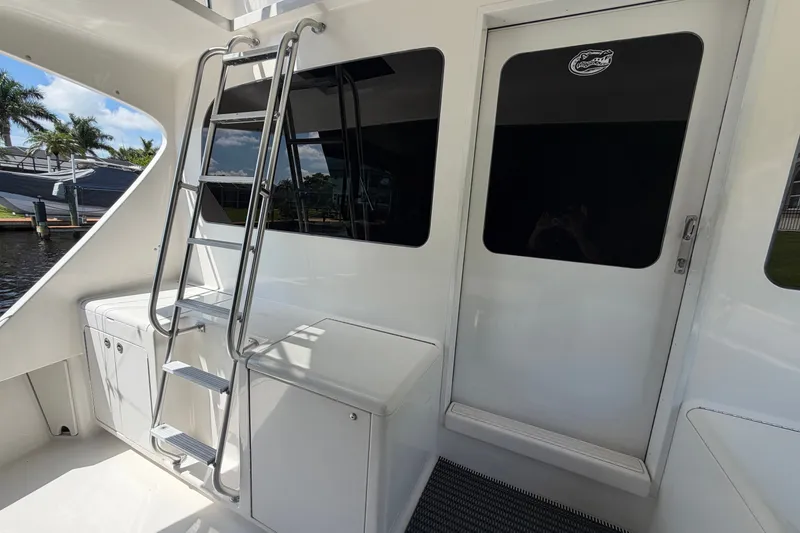 Slide: The Image of 2007 Post 50 Convertible yacht with ladder and door, docked near palm trees. - 14