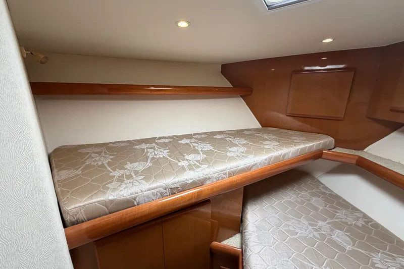 Slide: The Image of 2007 Post 50 Convertible yacht interior with twin bunk beds and wooden accents. - 98