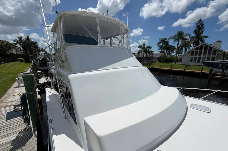 Slide: The Image of 2007 Post 50 Convertible yacht docked by a waterfront home under a partly cloudy sky. - 5