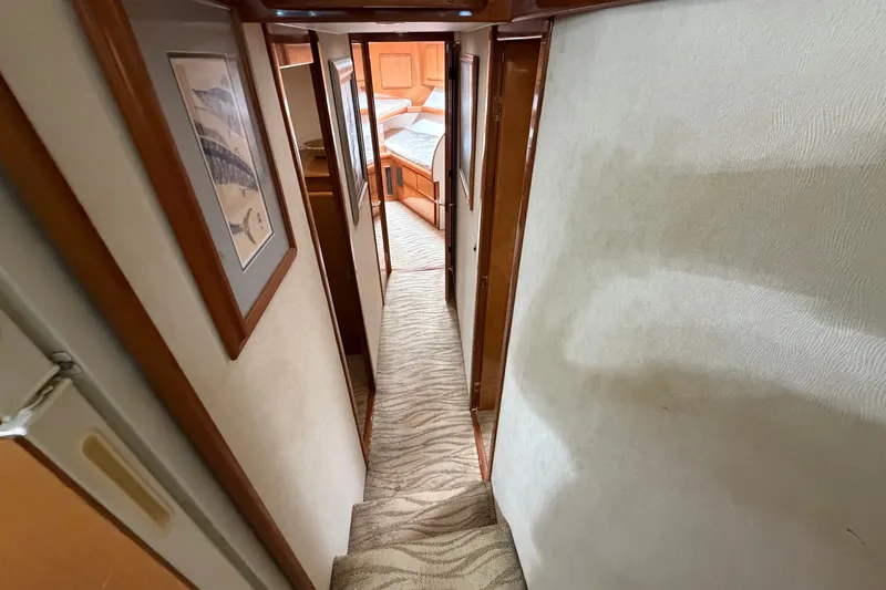 Slide: The Image of Interior hallway of a 2007 Post 50 Convertible yacht, featuring carpeted stairs and framed artwork. - 72