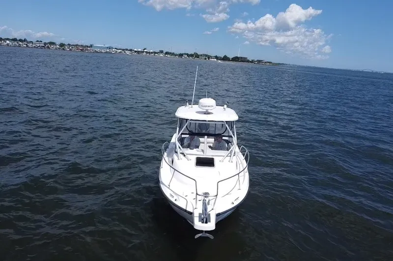 Slide: The Image of 2005 Boston Whaler 235 Conquest boat on open water under blue sky. - 11