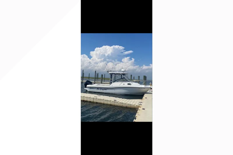 Slide: The Image of 2005 Boston Whaler 235 Conquest docked under a clear blue sky. - 18