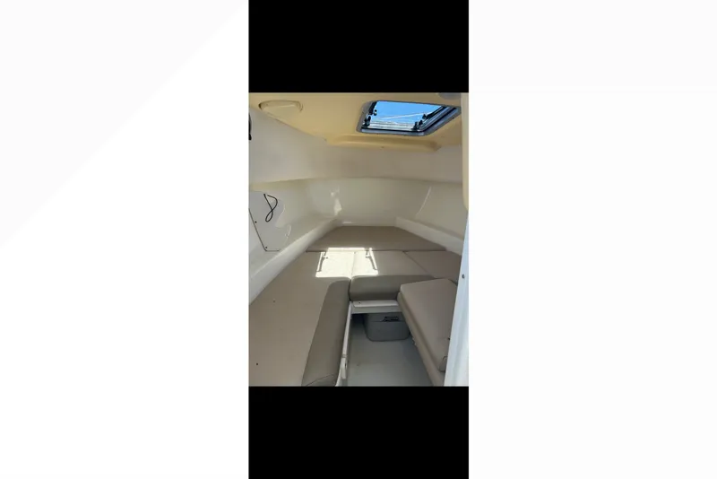 Slide: The Image of Interior cabin of 2005 Boston Whaler 235 Conquest boat with beige seating and overhead hatch. - 22
