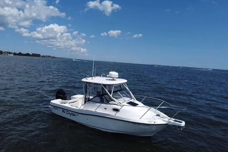 Slide: The Image of 2005 Boston Whaler 235 Conquest boat on open water under blue sky. - 5