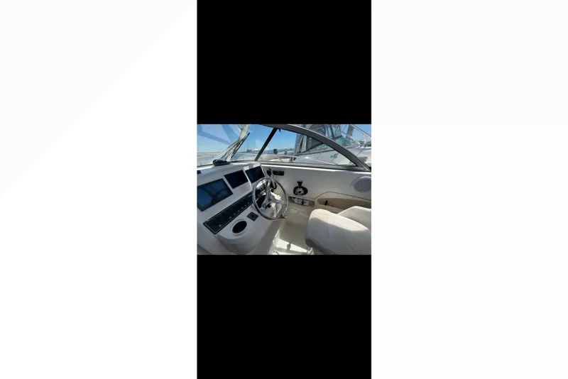 Slide: The Image of 2005 Boston Whaler 235 Conquest boat cockpit with steering wheel and control panel. - 20
