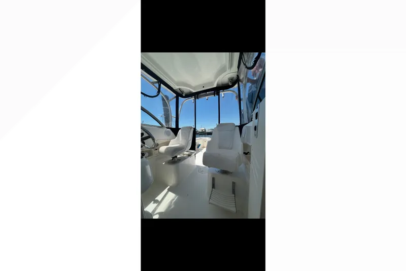 Slide: The Image of Interior view of 2005 Boston Whaler 235 Conquest boat cockpit with seating and steering wheel. - 14