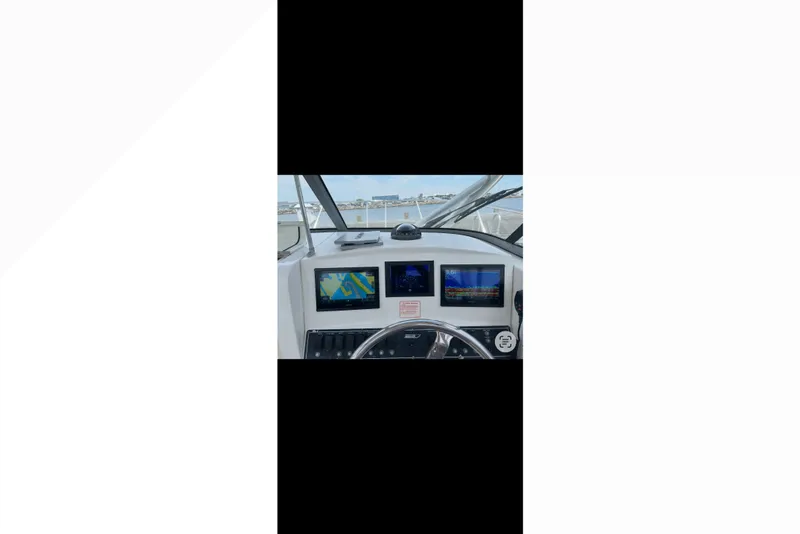 Slide: The Image of Dashboard of a 2005 Boston Whaler 235 Conquest boat with navigation screens. - 12