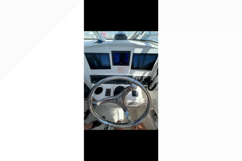 Slide: The Image of Steering wheel and dashboard of a 2005 Boston Whaler 235 Conquest boat. - 19