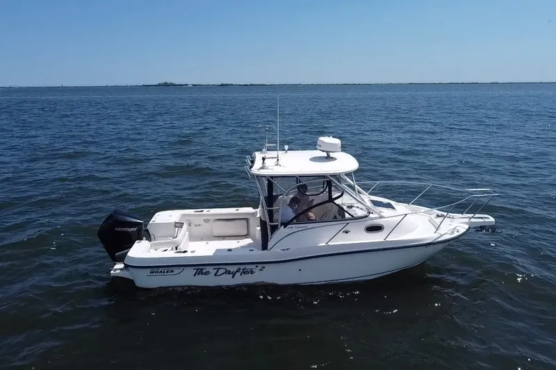 Slide: The Image of 2005 Boston Whaler 235 Conquest boat on open water, side view. - 4