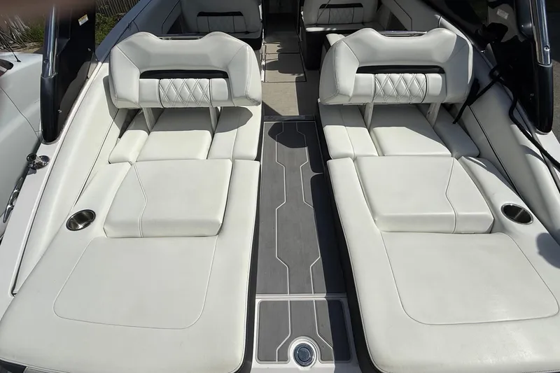 Slide: The Image of 2021 Regal LS6 boat interior with white cushioned seating and cup holders. - 11