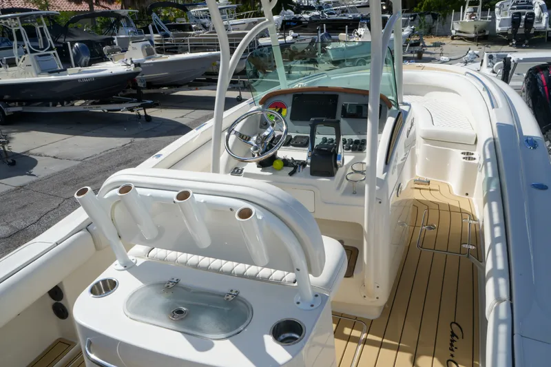 Slide: The Image of 2008 Chris-Craft Catalina 26 boat interior with helm, rod holders, and teak flooring. - 11