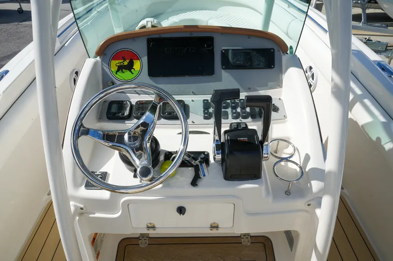 Slide: The Image of 2008 Chris-Craft Catalina 26 helm with steering wheel, controls, and dashboard instruments. - 14