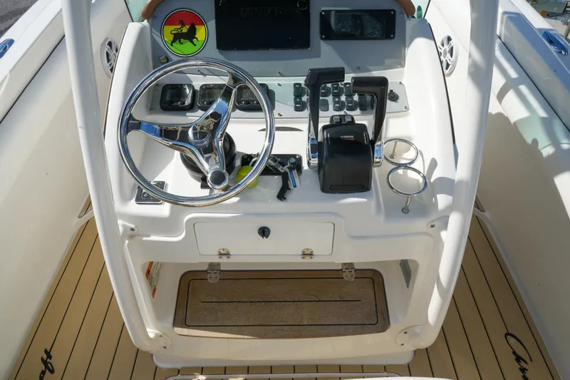 Slide: The Image of 2008 Chris-Craft Catalina 26 helm with steering wheel, controls, and cup holders. - 15