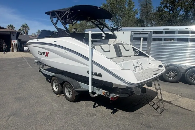 Slide: The Image of 2022 Yamaha Boats 252XE on trailer, parked outdoors, showcasing sleek design and modern features. - 5