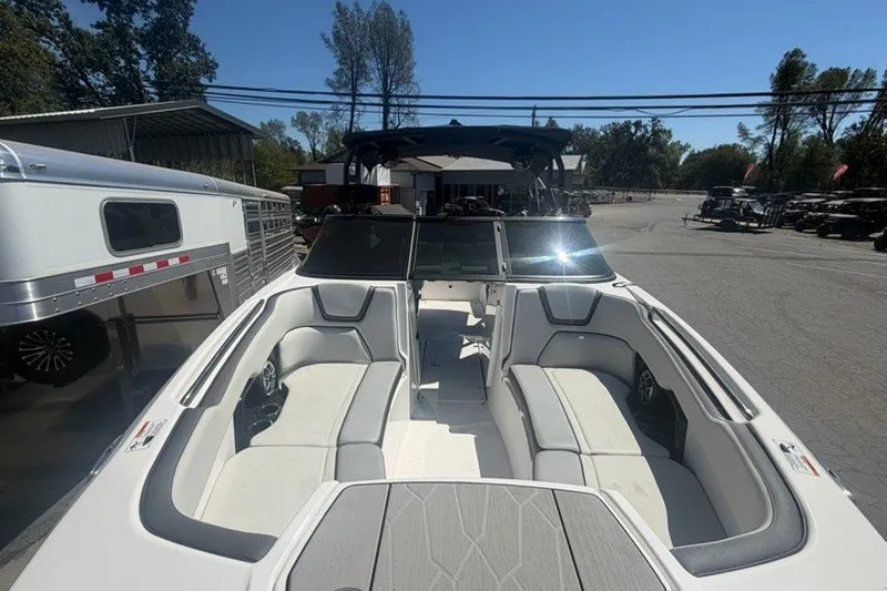 Slide: The Image of 2022 Yamaha Boats 252XE with spacious seating, parked outdoors under clear skies. - 12