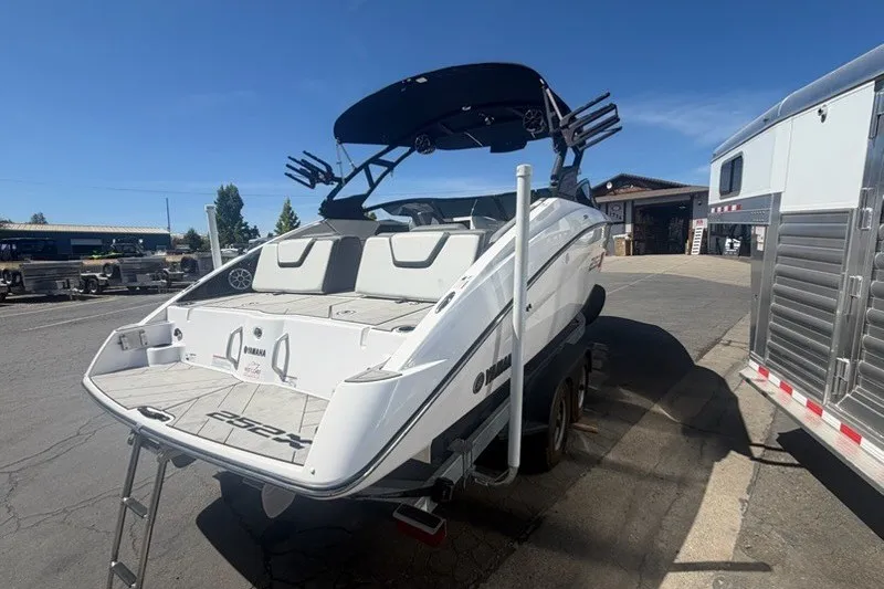 Slide: The Image of 2022 Yamaha Boats 252XE on trailer, rear view, parked outdoors under clear sky. - 8