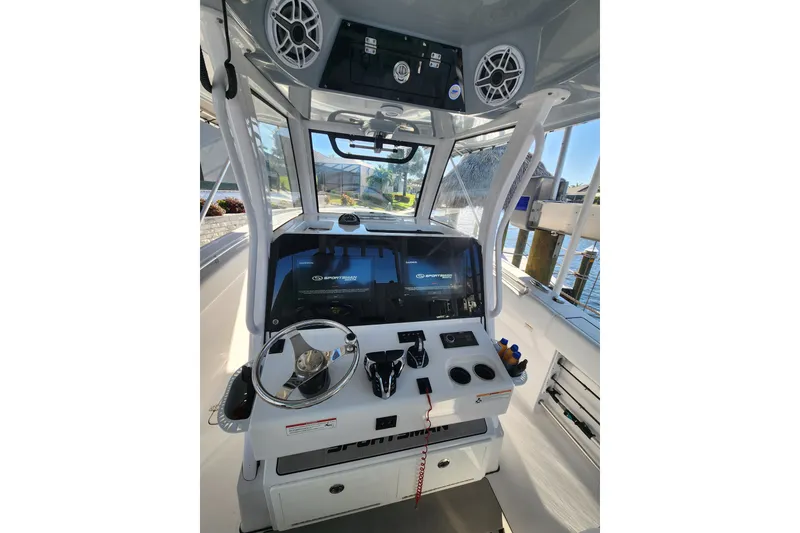 Slide: The Image of 2025 Sportsman Open 322 Center Console boat dashboard with steering wheel and controls. - 9