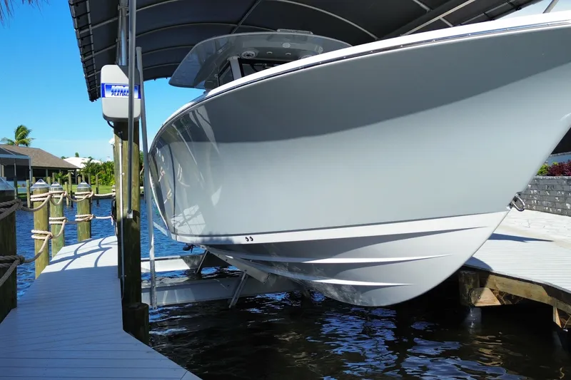 Slide: The Image of 2025 Sportsman Open 322 Center Console boat docked under a canopy. - 3