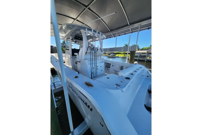 Slide: The Image of 2025 Sportsman Open 322 Center Console boat docked under a canopy, showcasing sleek design. - 12