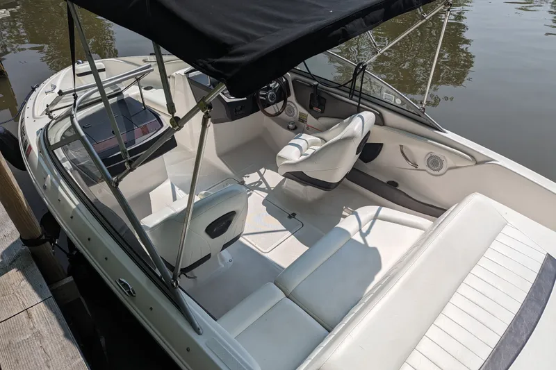 Slide: The Image of 2008 Regal 1900 LSR boat interior with white seating and black canopy. - 14