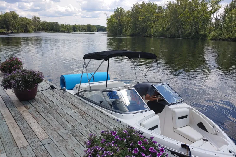 The Image of 2008 Regal 1900 LSR boat docked on a serene lake with lush greenery. - 15