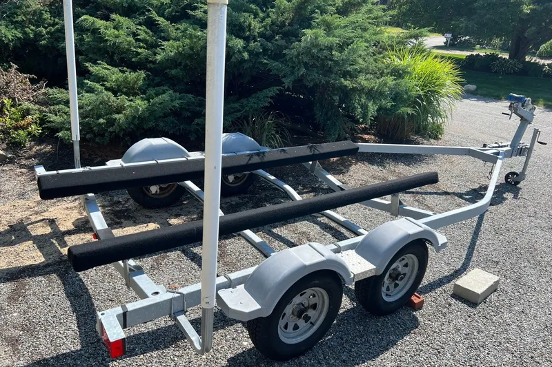 Slide: The Image of Boat trailer for 2021 Boston Whaler 190 Montauk, parked on gravel driveway. - 13