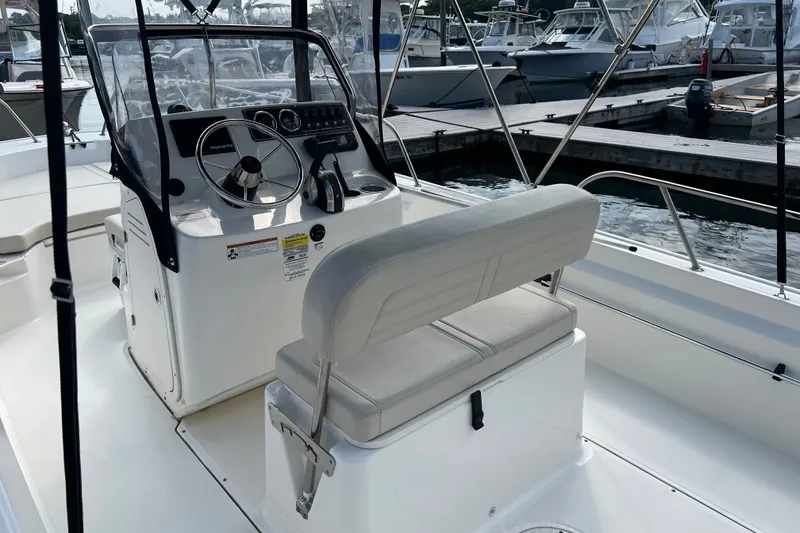 Slide: The Image of 2021 Boston Whaler 190 Montauk boat interior with steering console and seating at marina. - 4
