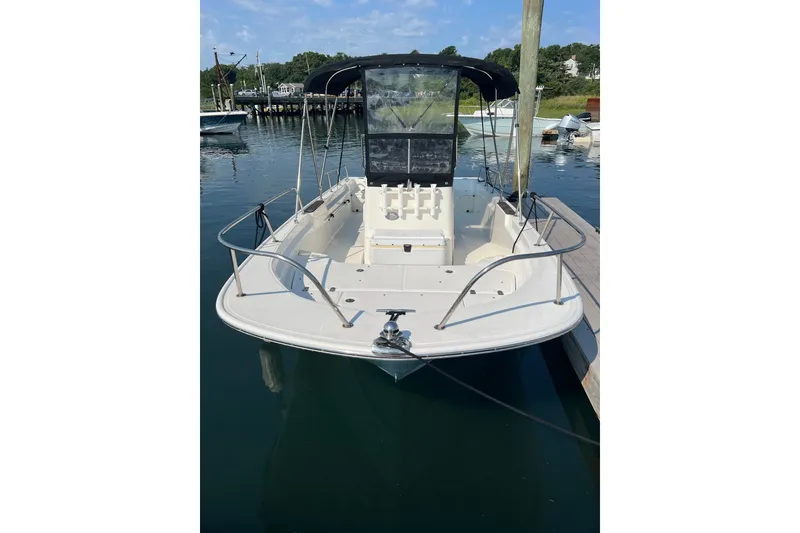 Slide: The Image of 2021 Boston Whaler 190 Montauk boat docked in a serene marina setting. - 1