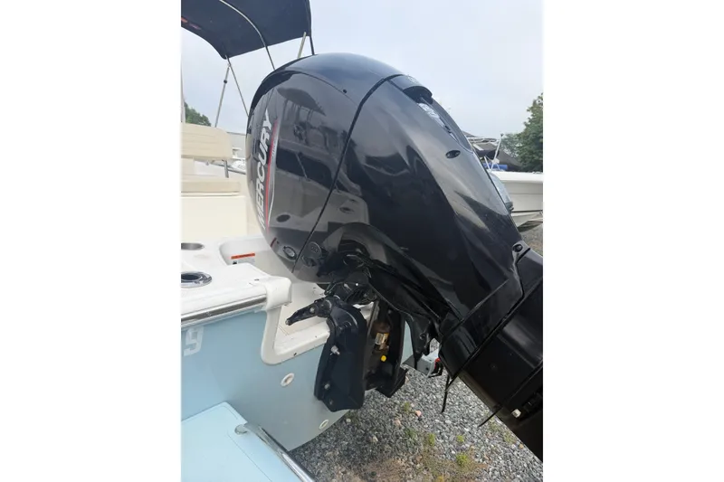 Slide: The Image of 2021 Boston Whaler 190 Montauk with Mercury outboard motor, parked on gravel. - 12